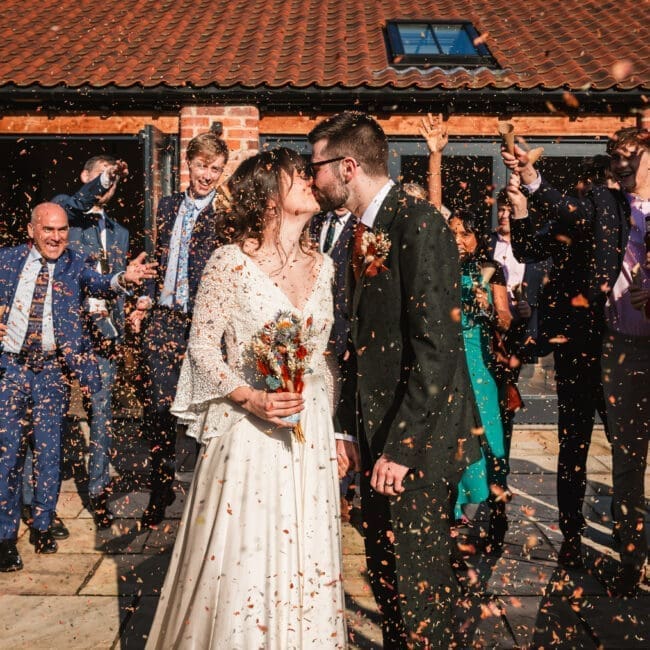 bride and groom kissing conffeti shot at thirsk barn lodges