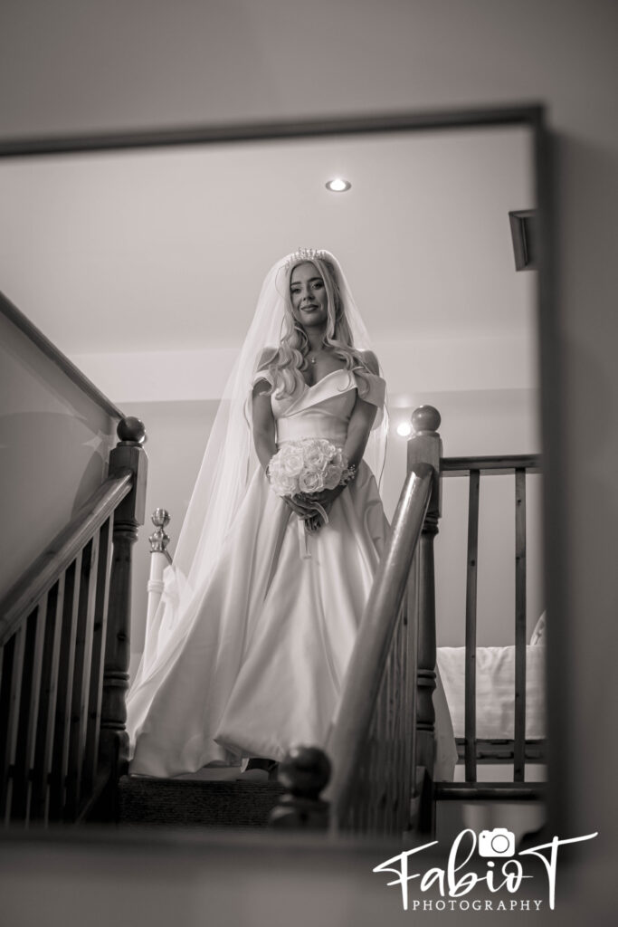 A bride walking down the stairs at the outbarn farm house before she goes to the venue
