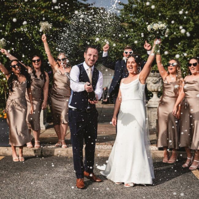 bride and groom spraying champagne at red hall hotel bury