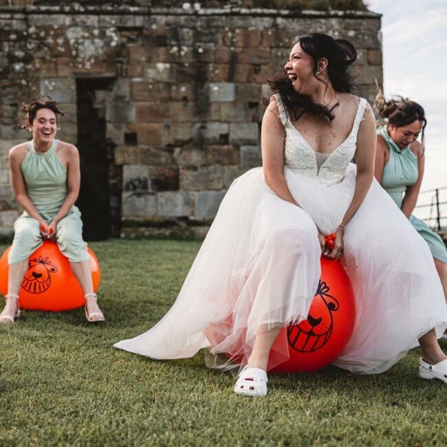 Sam & Kirsty – 0588 Bride on space hooper at danby castle with bridesmaids behind