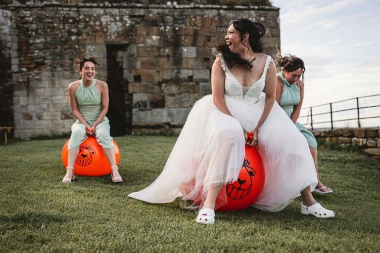 Bride on space hooper at danby castle with bridesmaids behind