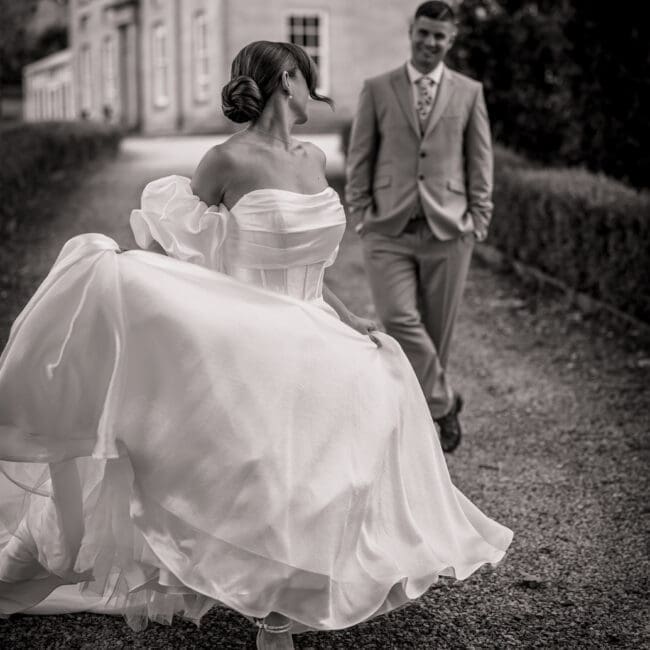 YorkshireWeddingStyledShoot -0256 A bride walking away from her groom in black and white with the dress flowing high at grassfield harrogate | Yorksire wedding photographer