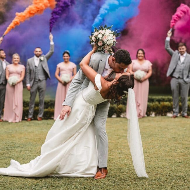 Smoke bombs at a wedding as groom dips the bride at East riddlesden hall | East riddlesden hall wedding photographer