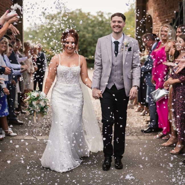 Jess & Alex – 1056 bride and groom walking through conffeti tunnel at hodsock priory