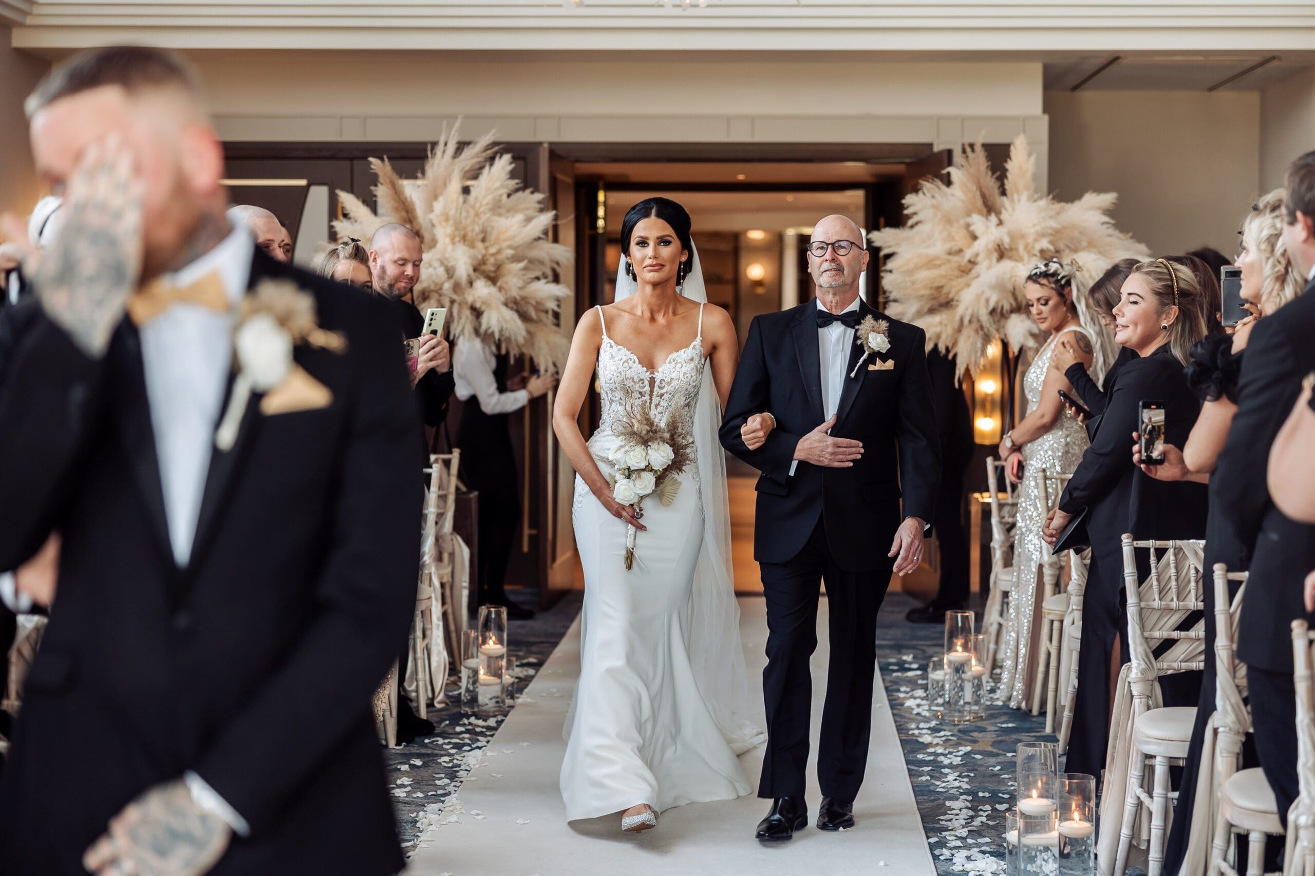 bride walking down aisle as groom emotionally waits at the front at crow wood hotel and spa