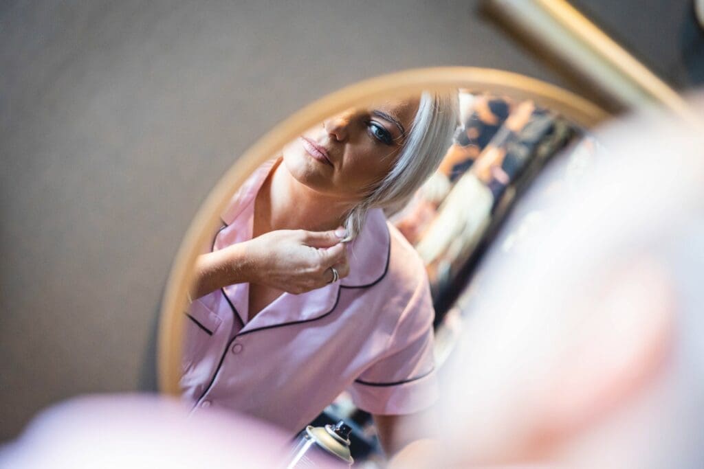 Bride getting ready, reflected in a mirror during bridal preparations at a Yorkshire manor house wedding