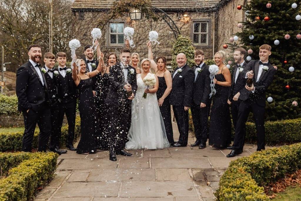 Mollie and Lewis celebrating with their wedding party and champagne at a winter Yorkshire wedding
