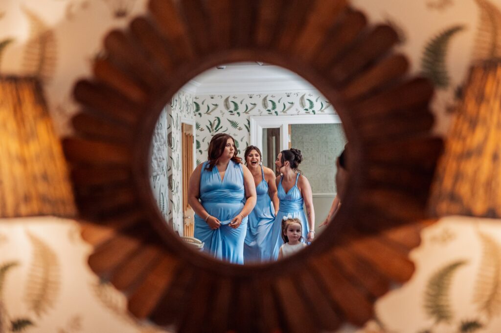 Bridesmaids reflected in a sunburst mirror at Wentbridge House Hotel.