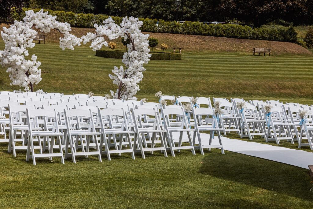 White chairs and blossom trees set out on the lawn for a garden ceremony at Wentbridge House Hotel.