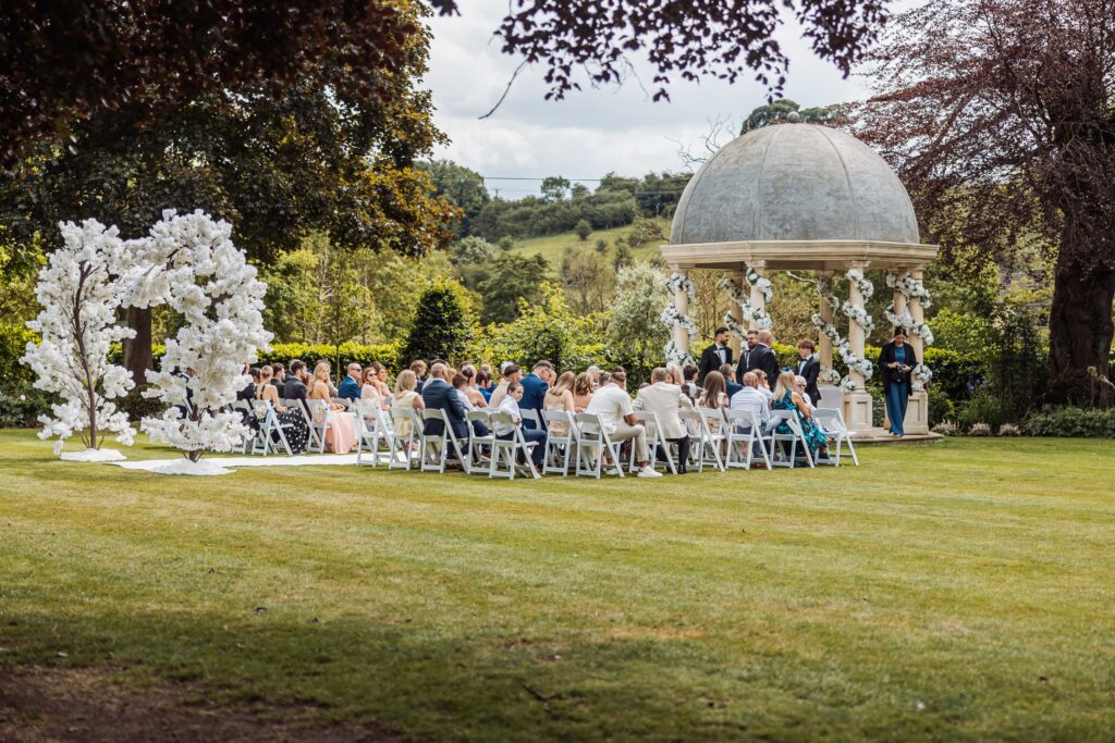 The outdoor ceremony underway at the stone pavilion, framed by the wooded valley at Wentbridge House Hotel.
