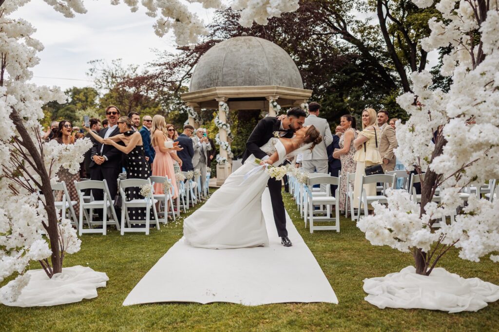 The full bridal party in pale blue and black tie on the lawn at Wentbridge House Hotel.