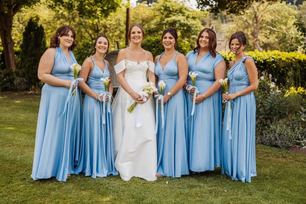 Bridesmaids in pale blue gowns photographed in the gardens at Wentbridge House Hotel.