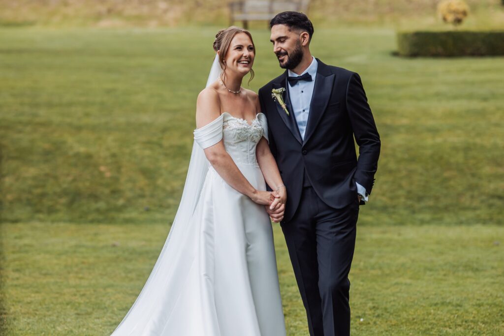 The newlyweds walk the lawns together in the wooded valley at Wentbridge House Hotel.