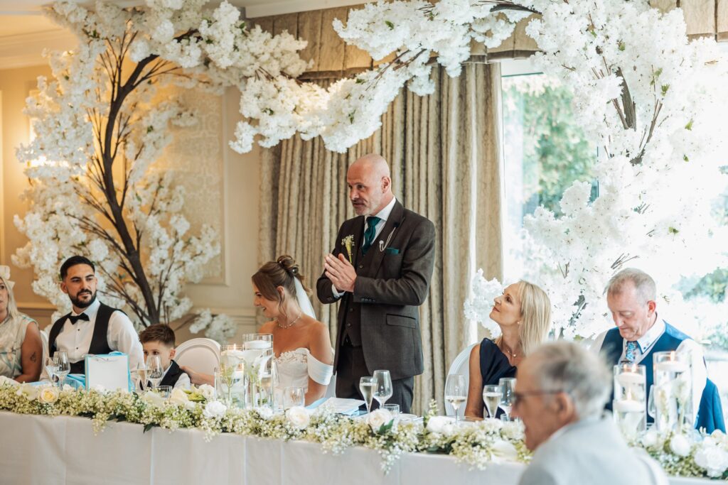 Guests applaud during the speeches at the blossom-decorated top table.