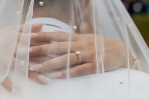 A close-up of a hand wearing a gold engagement ring with a large central diamond and smaller diamonds along the band at Woodlands Hotel, Leeds
