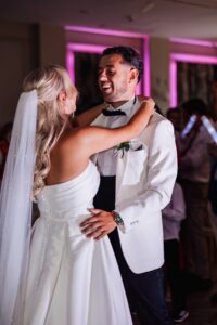 A couple in wedding attire dances closely together during a first dance at a wedding reception at Woodlands Hotel, Leeds
