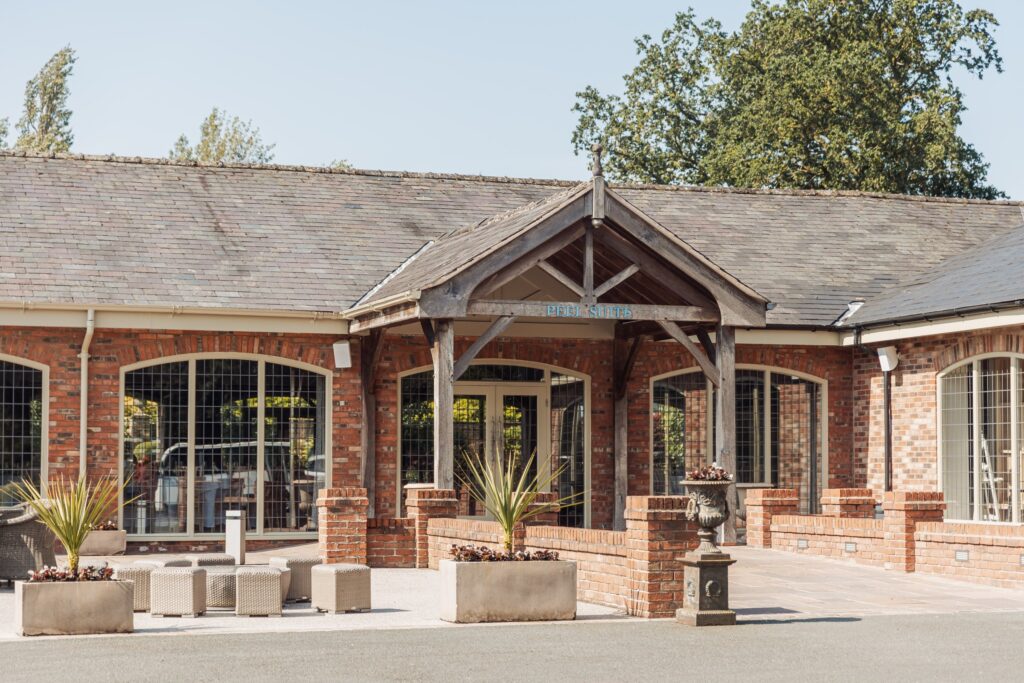 A brick building with a sloped roof and a covered entrance, labelled 'PEEL SUITE'