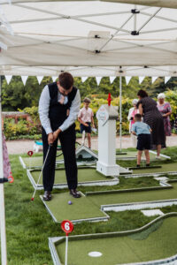 Wedding guests playing crazy golf on the lawn at Hodsock Priory between the meal and the evening