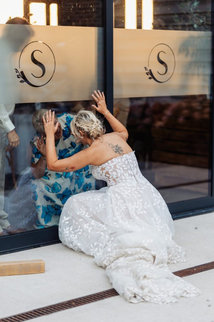 Bride leaning against the monogrammed panel inside the barn at Sedgewell Barn