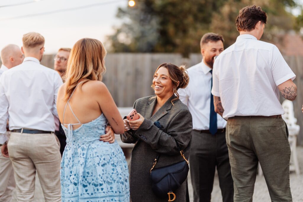 Guests chatting outdoors during the drinks reception at Sedgewell Barn