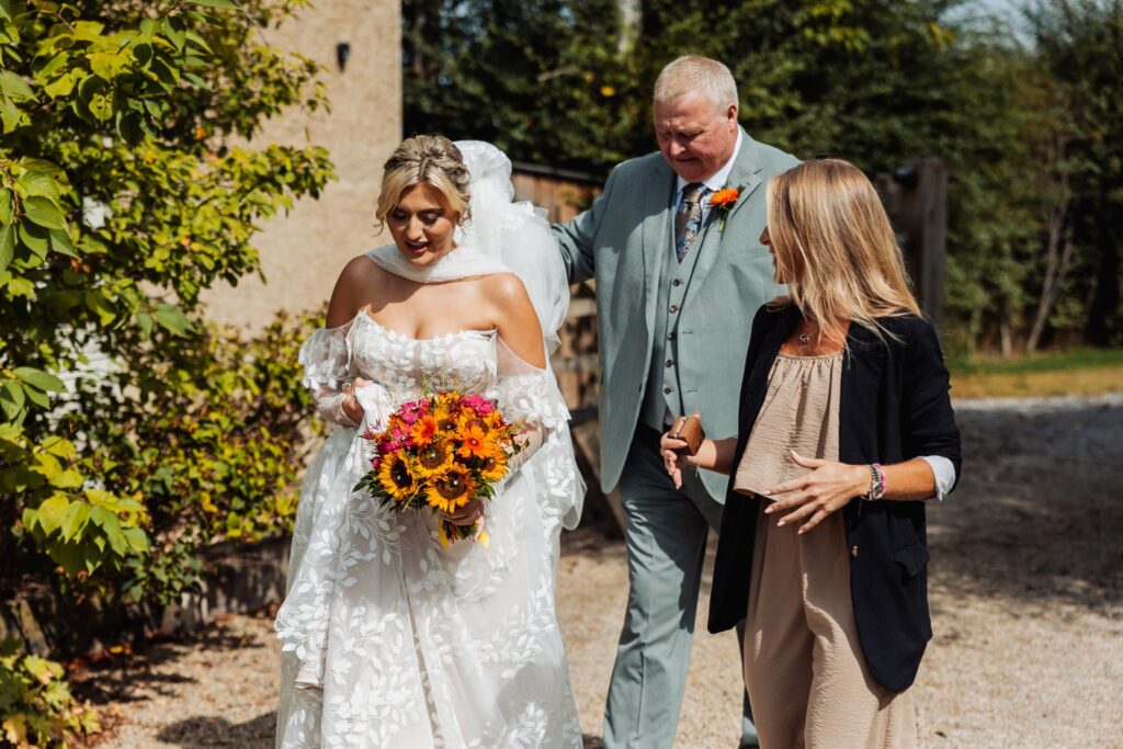 Bride walking outside with her father before the ceremony at Sedgewell Barn