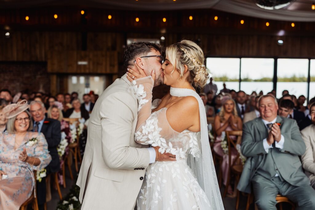 Bride and groom share their first kiss during the ceremony at Sedgewell Barn