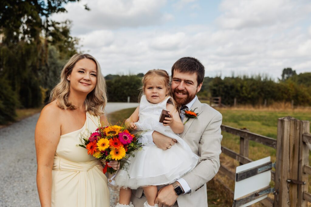 Bridesmaid and guest holding a baby outside at Sedgewell Barn
