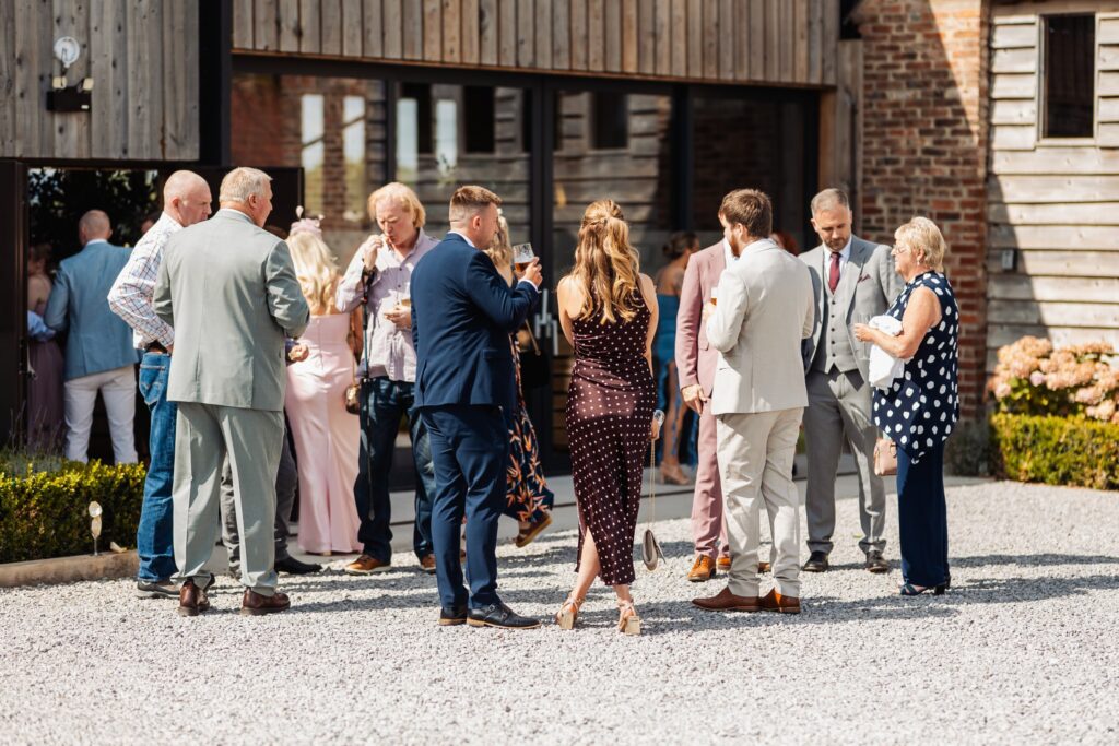 Guests gathered outside the barn during the drinks reception at Sedgewell Barn