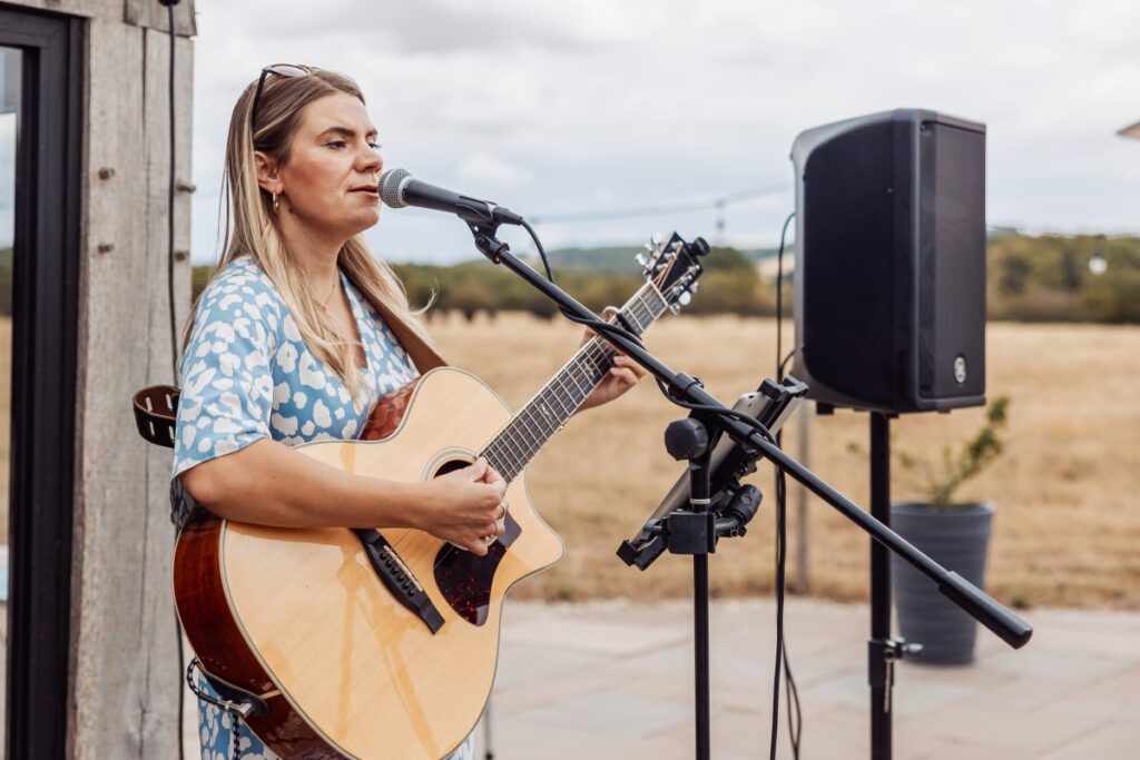 An acoustic singer performs on the patio at Clayfield Farm, looking out over the East Yorkshire countryside.