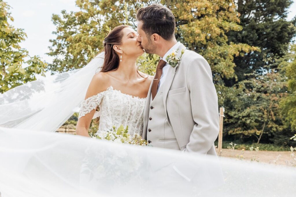 Bride and groom photographed under her veil, foreheads close, on a summer afternoon in East Yorkshire.