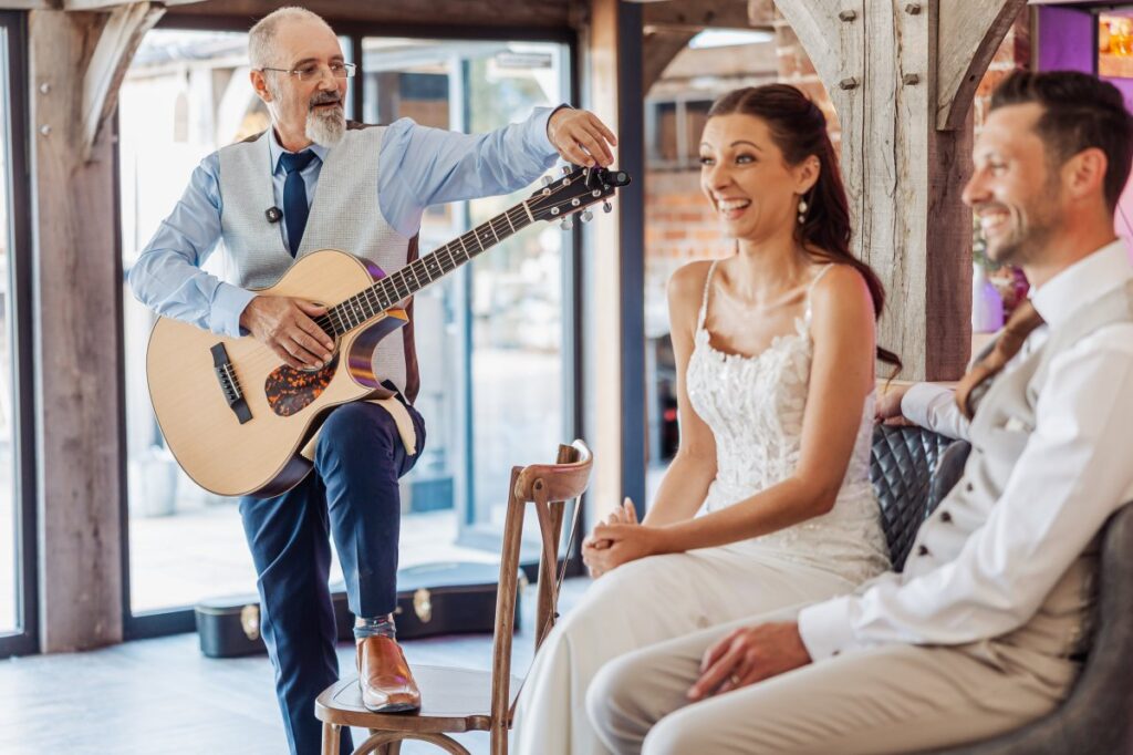 An acoustic guitarist plays for the bride and groom in the bar at Clayfield Farm.
